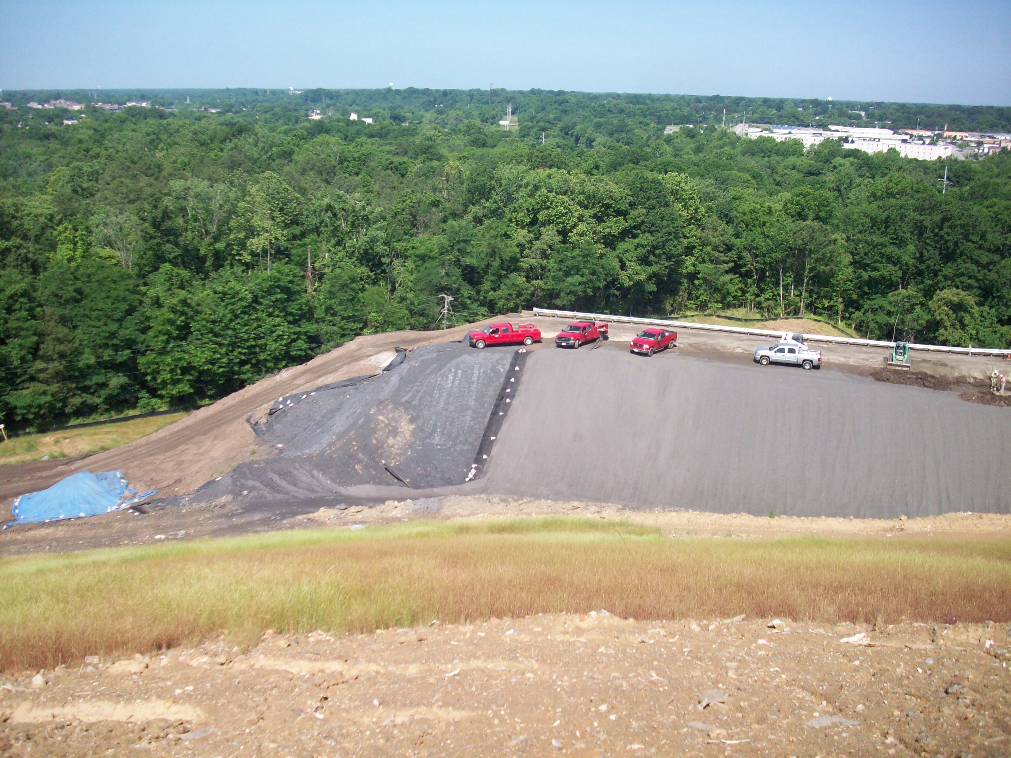 Field crew installing geosynthetic liner on landfill slope